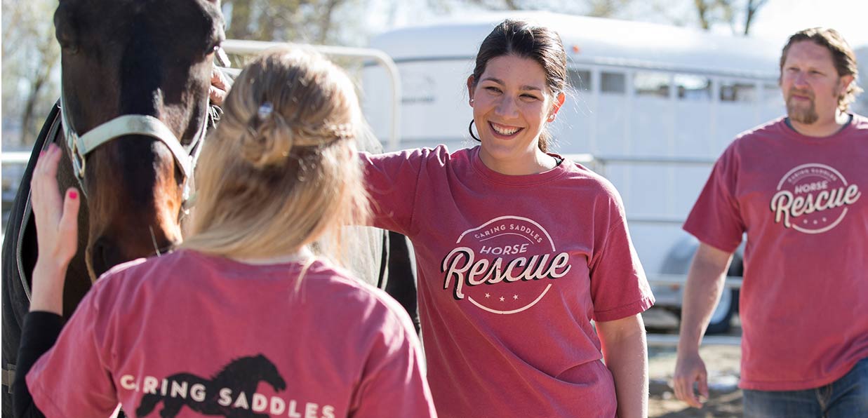 Two women work together on the farm for a horse rescue. 